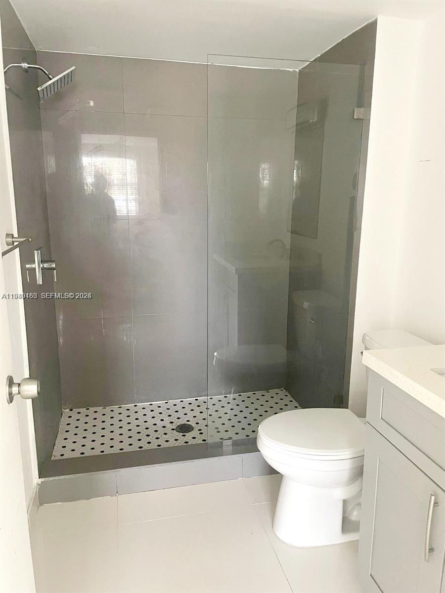 8821 Wiles Road, Unit 101 Coral Springs, FL 33067 - Photo 11 of 16 a bathroom with a shower and a toilet