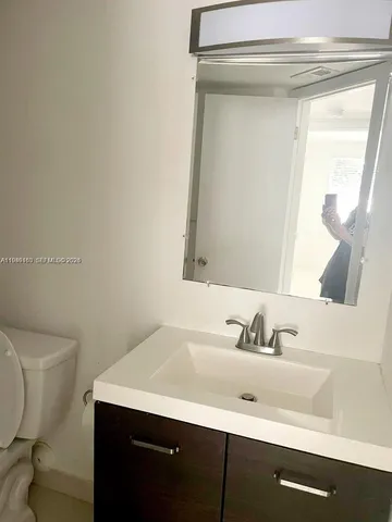 a bathroom with a sink a toilet and mirror