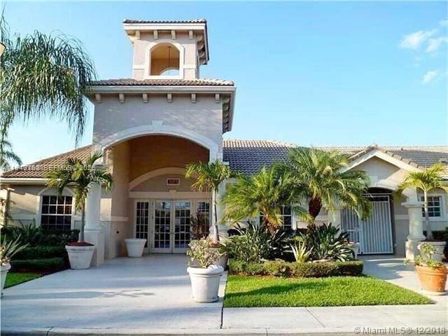 8821 Wiles Road, Unit 101 Coral Springs, FL 33067 - Photo 3 of 16 a front view of a house with garden