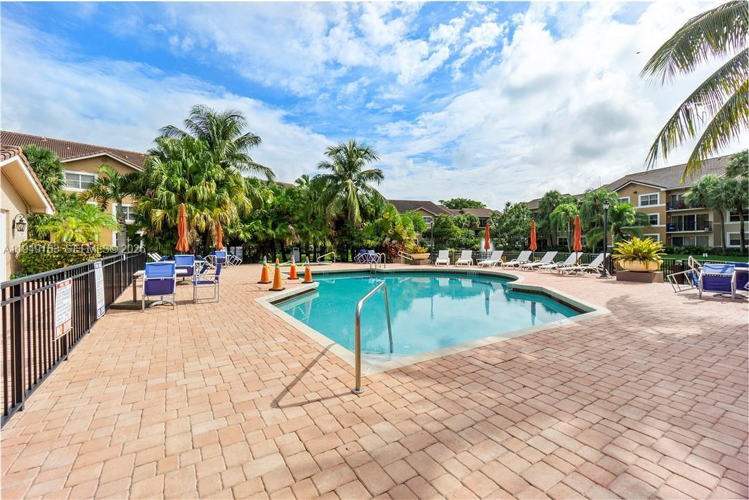 8821 Wiles Road, Unit 101 Coral Springs, FL 33067 - Photo 5 of 16 a swimming pool with outdoor seating and yard