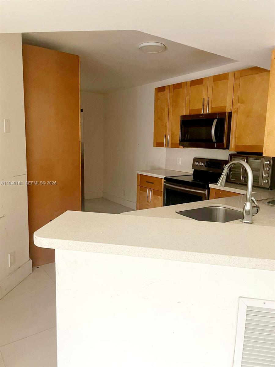 8821 Wiles Road, Unit 101 Coral Springs, FL 33067 - Photo 9 of 16 a bedroom with a bed and a flat screen tv