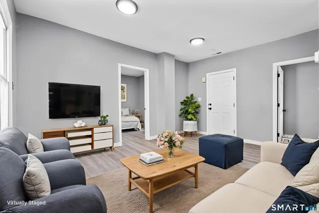 a view of an empty room with wooden floor and closet