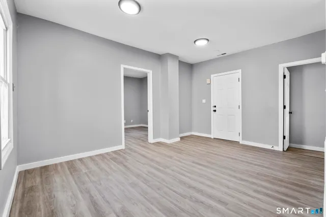 a view of an empty room with wooden floor