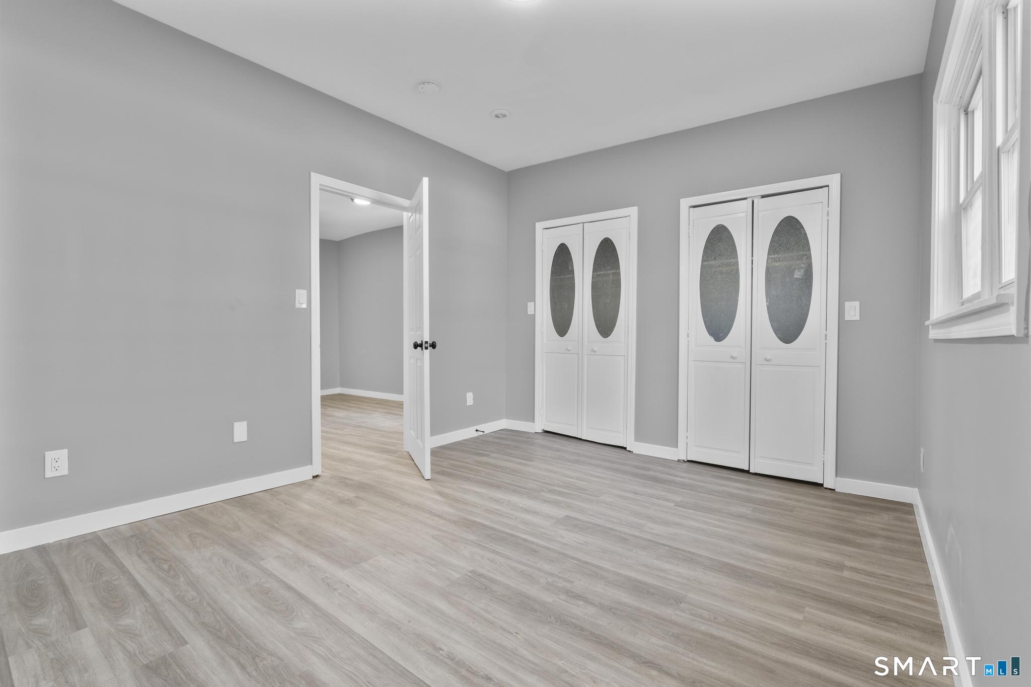 257 North State Street Ansonia, CT 06401 - Photo 24 of 39 an empty room with wooden floor and windows