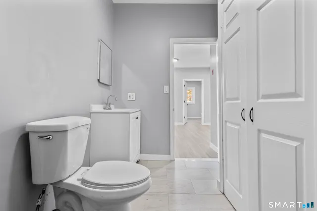 a view of an empty room with wooden floor and closet
