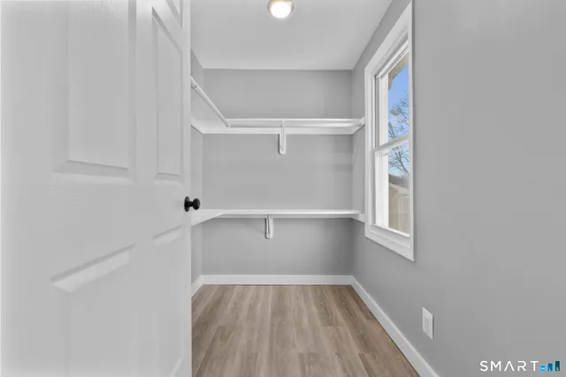 a view of a hallway with wooden floor and a window