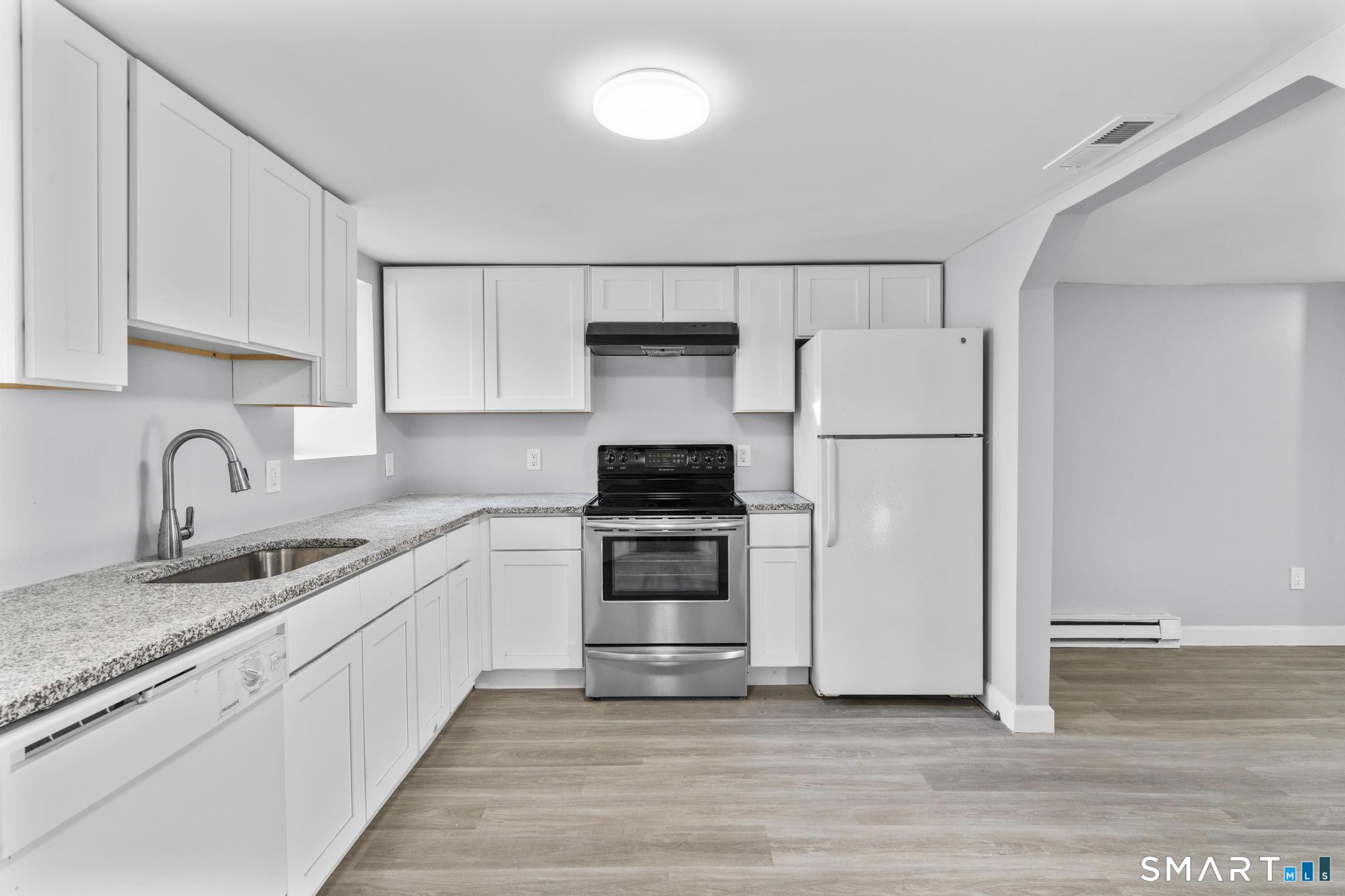 257 North State Street Ansonia, CT 06401 - Photo 8 of 39 a kitchen with granite countertop white cabinets and stainless steel appliances