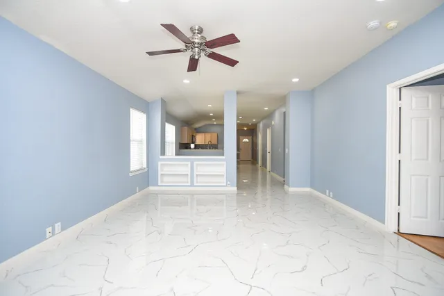 a view of a livingroom with a ceiling fan and window
