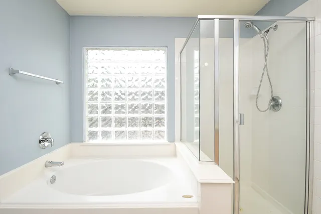 a white bath tub sitting next to a shower