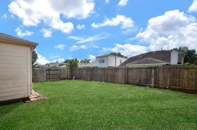 a view of a backyard with potted plants and wooden fence