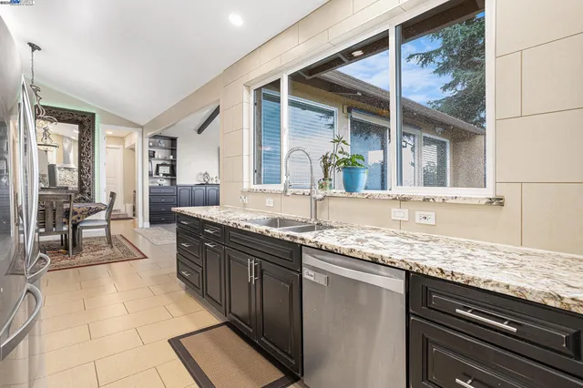 a large kitchen with granite countertop a sink and a stove