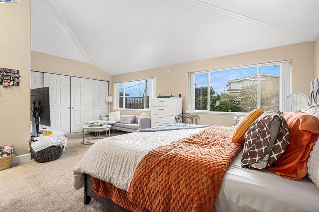 a bedroom with a bed and large windows