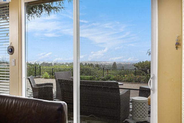 a view of a glass door with a balcony from a window