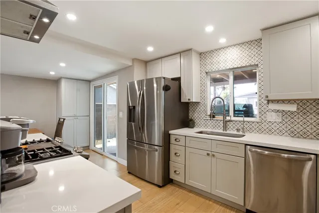 a kitchen with stainless steel appliances granite countertop a sink stove and refrigerator