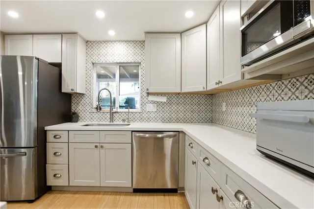 a kitchen with a sink a refrigerator and cabinets