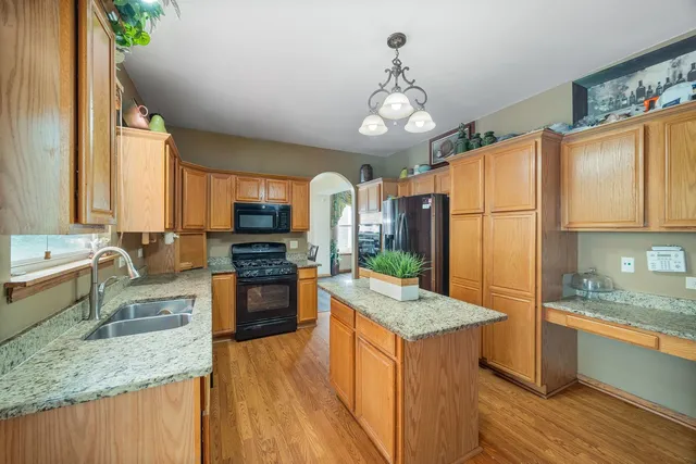 a kitchen with stainless steel appliances granite countertop a stove refrigerator and microwave