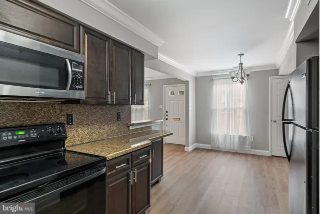 a kitchen with granite countertop wooden cabinets and stainless steel appliances