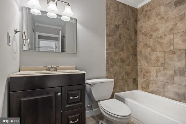 a bathroom with a sink vanity mirror and toilet