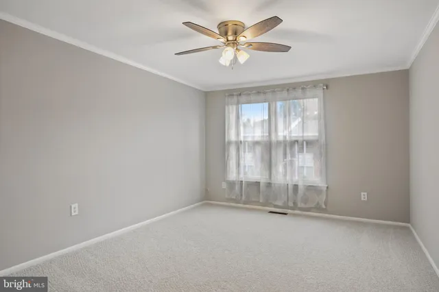 an empty room with a empty space and a ceiling fan