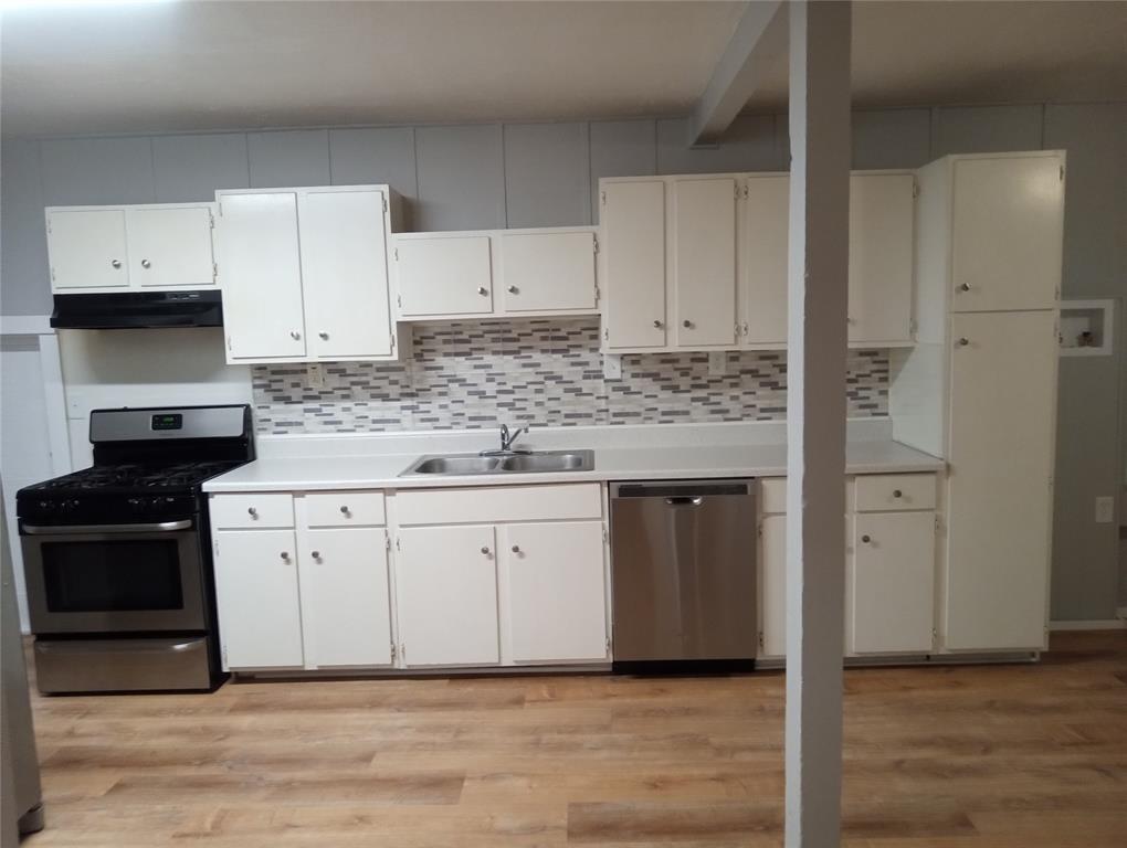 4500 Avenue D, Unit B Austin, TX 78751 - Photo 5 of 16 Kitchen with stainless steel appliances, light countertops, white cabinets, and light wood-style floors