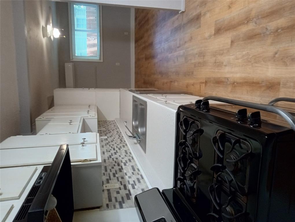 4500 Avenue D, Unit B Austin, TX 78751 - Photo 7 of 16 Kitchen featuring stainless steel range with gas cooktop, light countertops, white cabinetry, light wood-style flooring, and decorative backsplash