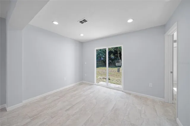 a view of empty room with window and ceiling fan