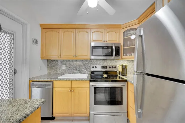 a kitchen with stainless steel appliances granite countertop a stove a sink and a microwave