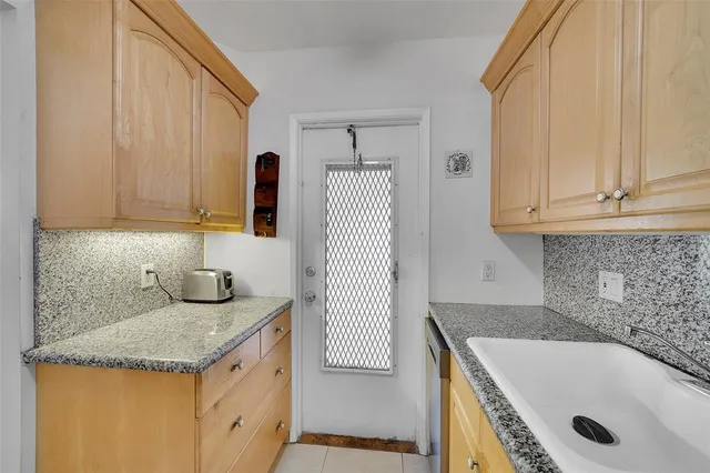 a bathroom with a granite countertop sink and washing machine