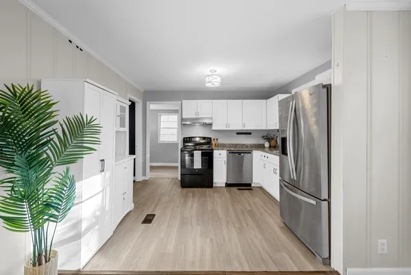 a kitchen with white cabinets and stainless steel appliances