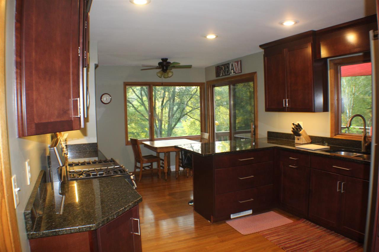 840 Spring Ridge Court Belvidere, IL 61008 - Photo 4 of 25 a kitchen with a sink dining table and chairs