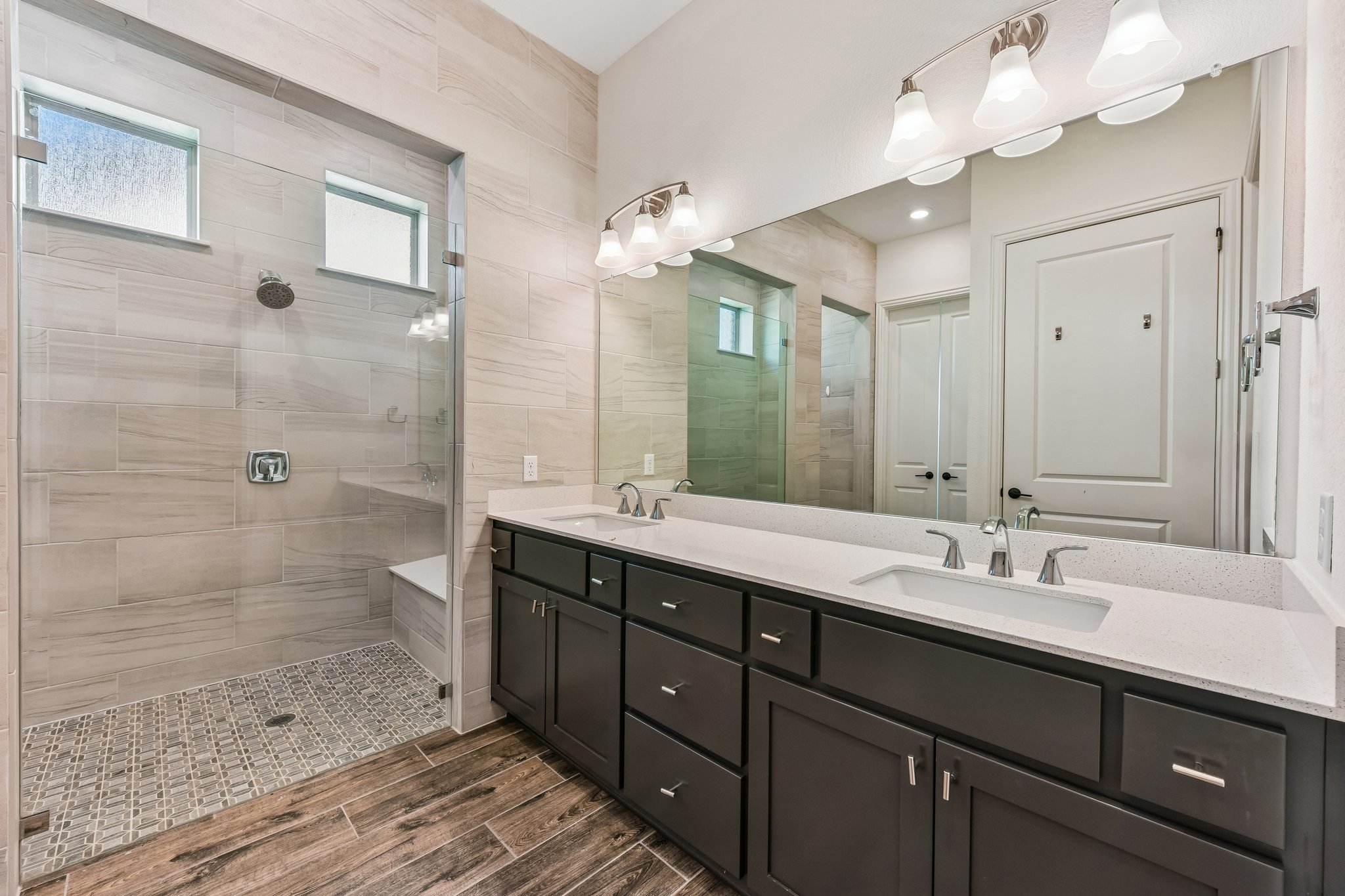 19113 Freeman Circle Austin, TX 78738 - Photo 7 of 37 A well-appointed primary bath features a spacious double vanity and a glass-enclosed walk-in shower.