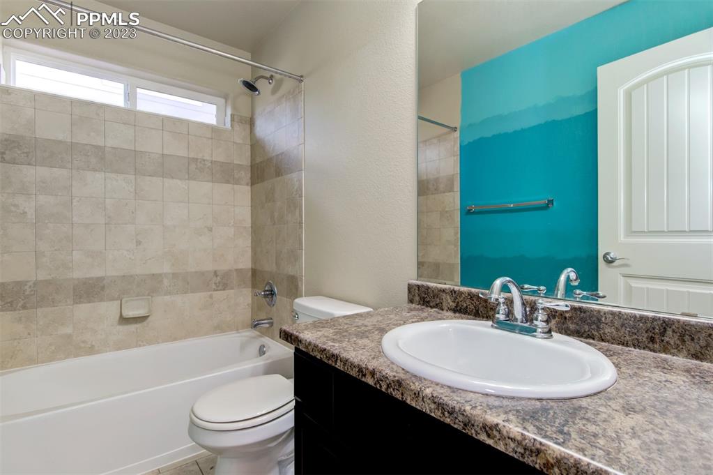 10034 Intrepid Way Colorado Springs, CO 80925 - Photo 12 of 31 a bathroom with a granite countertop sink toilet a mirror and shower