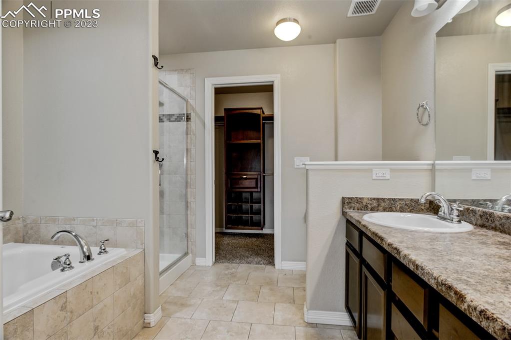10034 Intrepid Way Colorado Springs, CO 80925 - Photo 17 of 31 a bathroom with a granite countertop sink and a mirror