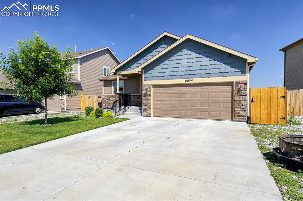 10034 Intrepid Way Colorado Springs, CO 80925 - Photo 2 of 31 a front view of a house with a yard and garage
