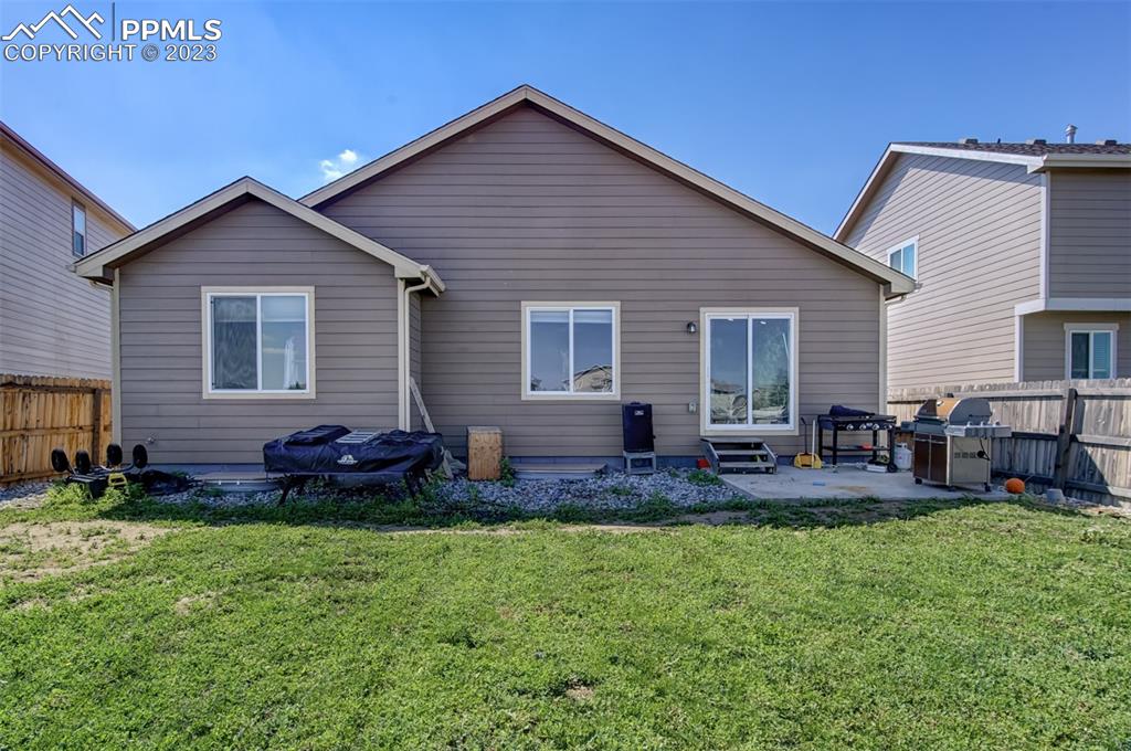 10034 Intrepid Way Colorado Springs, CO 80925 - Photo 30 of 31 a front view of house with yard and outdoor seating