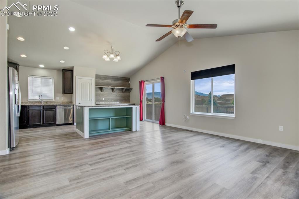 10034 Intrepid Way Colorado Springs, CO 80925 - Photo 5 of 31 an empty room with wooden floor staircase and windows
