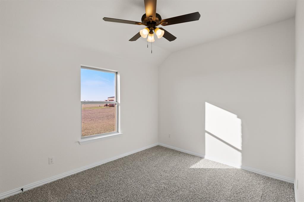186 County Road 4430 Rhome, TX 76078 - Photo 17 of 40 an empty room with windows and fan