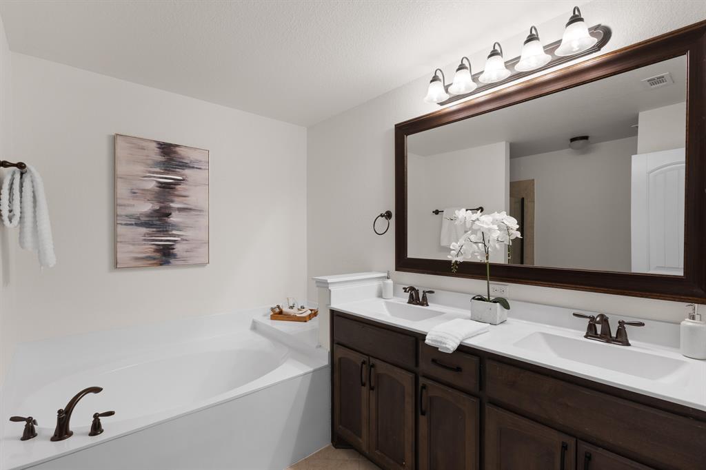 186 County Road 4430 Rhome, TX 76078 - Photo 20 of 40 a bathroom with a double vanity sink mirror and bathtub