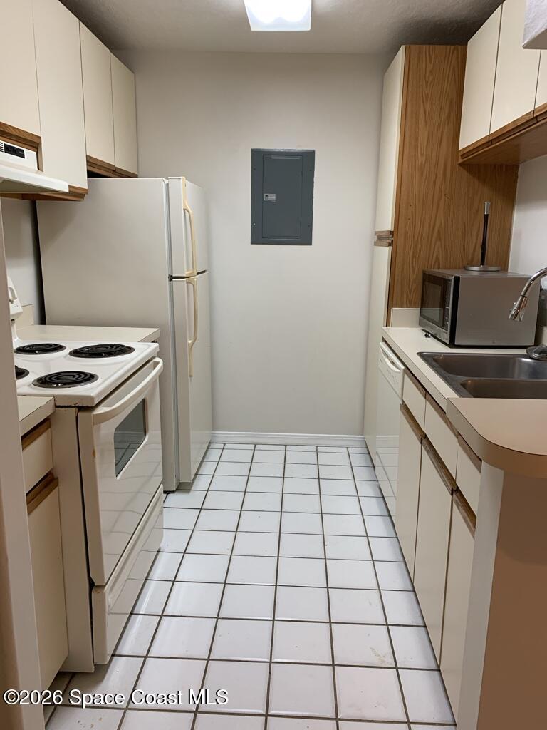 7667 North Wickham Road, Unit 720 Melbourne, FL 32940 - Photo 12 of 28 a kitchen with a stove a refrigerator and a sink