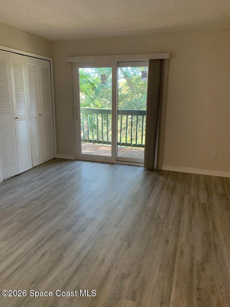 7667 North Wickham Road, Unit 720 Melbourne, FL 32940 - Photo 16 of 28 a view of an empty room with wooden floor and a window