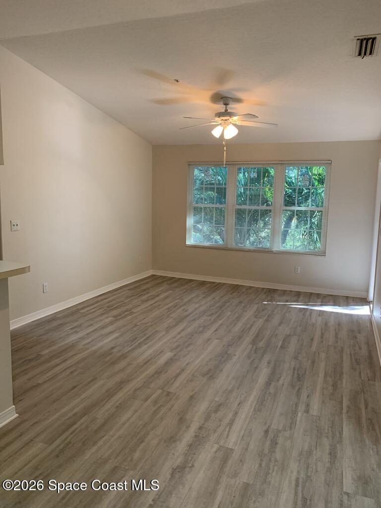 7667 North Wickham Road, Unit 720 Melbourne, FL 32940 - Photo 6 of 28 an empty room with wooden floor and windows