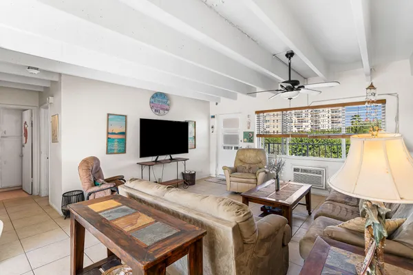 a living room with furniture a flat screen tv and a large window