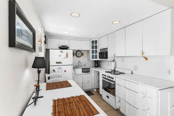 a kitchen with white cabinets stove and sink