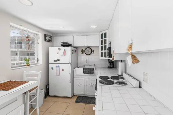 a kitchen with a refrigerator a stove top oven and a window