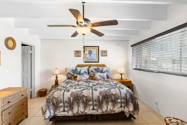 a bedroom with a bed and painting on the wall