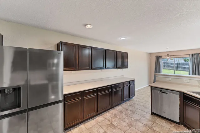 a kitchen with stainless steel appliances granite countertop a refrigerator and a sink