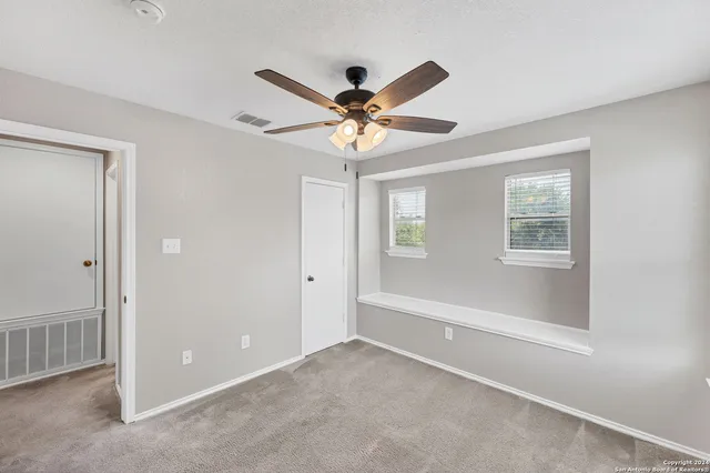 a view of a room with a ceiling fan and a window