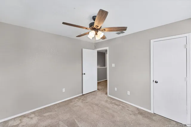 an empty room and chandelier fan