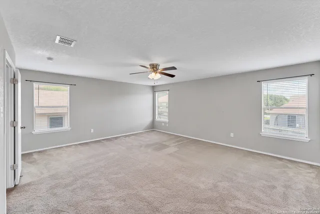 an empty room with a window and a ceiling fan