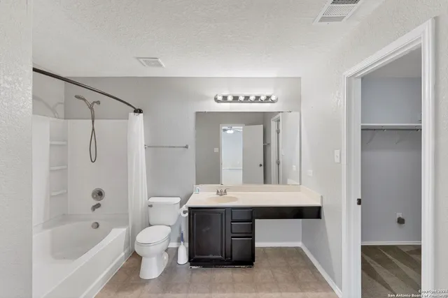 a bathroom with a bathtub shower sink and a toilet